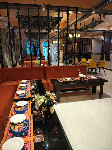 Outdoor seating with pasta and cocktails at Blue Lake Bistro Jhansi